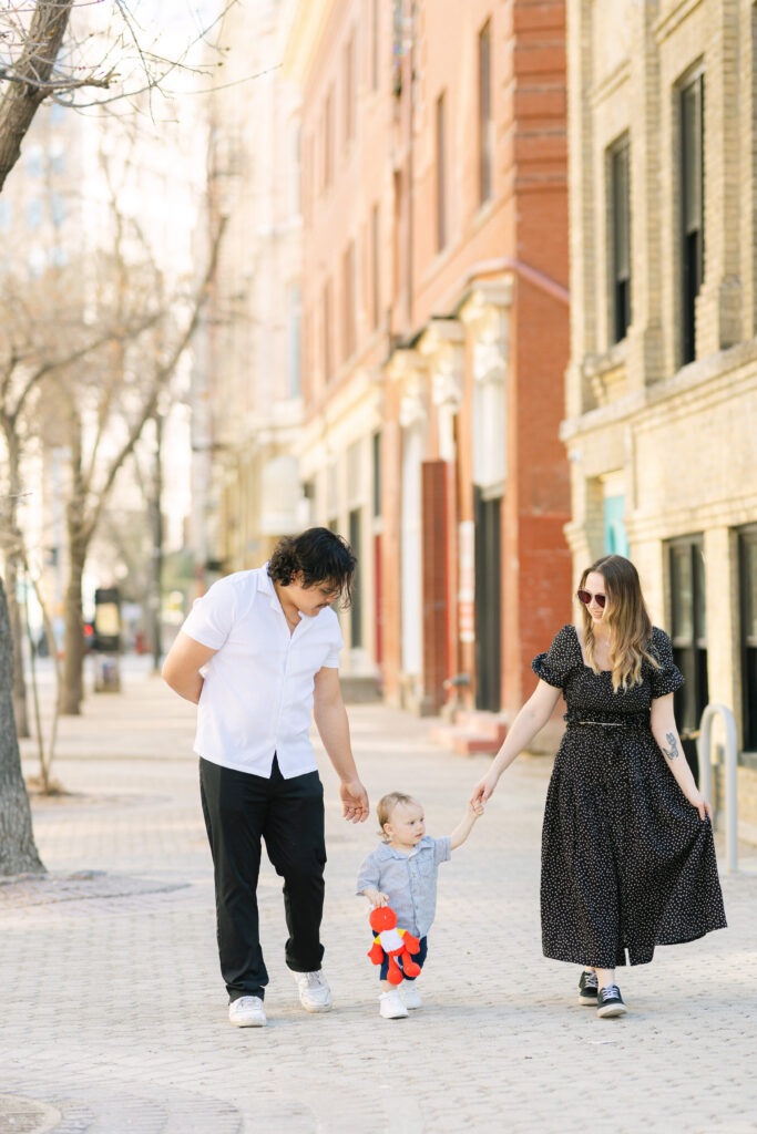 Family walking together in the Exchange District in Winnipeg with historic buildings and soft natural light