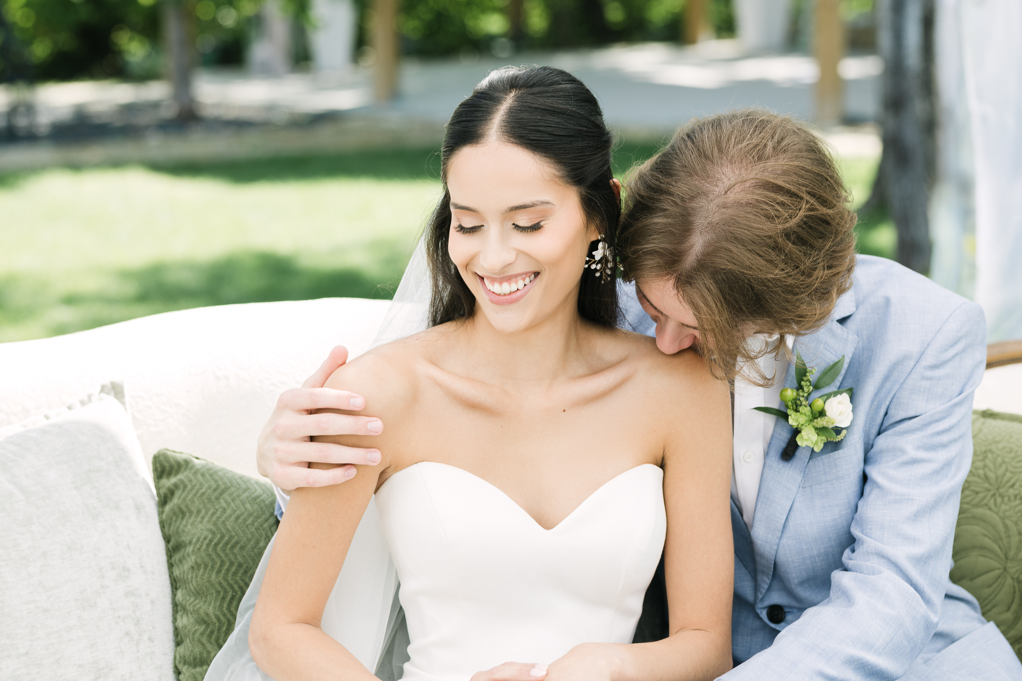 Fine art wedding photography in Winnipeg featuring a romantic couple portrait in the English Garden at Assiniboine Park, framed by a white chapel and captured with soft natural light and a timeless, editorial aesthetic.