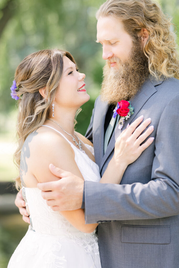 Fine art wedding photography at Bella’s Castle in Morden, Manitoba featuring a bride and groom walking together and sharing a natural, joyful moment, captured with soft light and a relaxed, editorial approach.