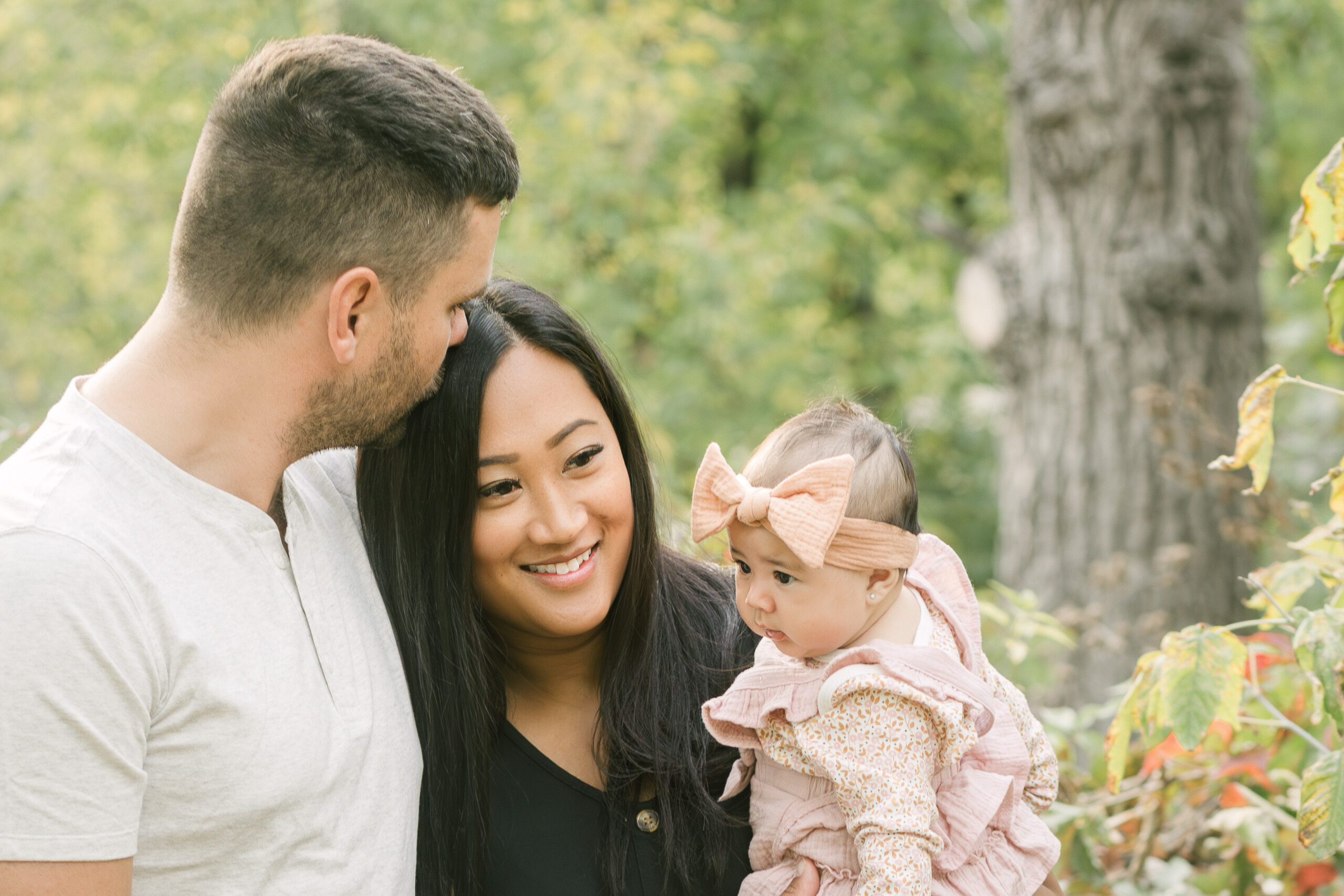parents holding baby girl at Stony Mountain Quarry during golden hour family session with wind movement