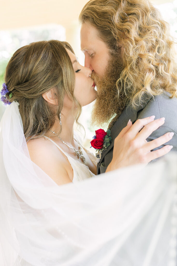 Fine art wedding photography at Bella’s Castle in Morden, Manitoba featuring a romantic close-up portrait of a bride and groom embracing, captured in soft natural light with a timeless, editorial feel.